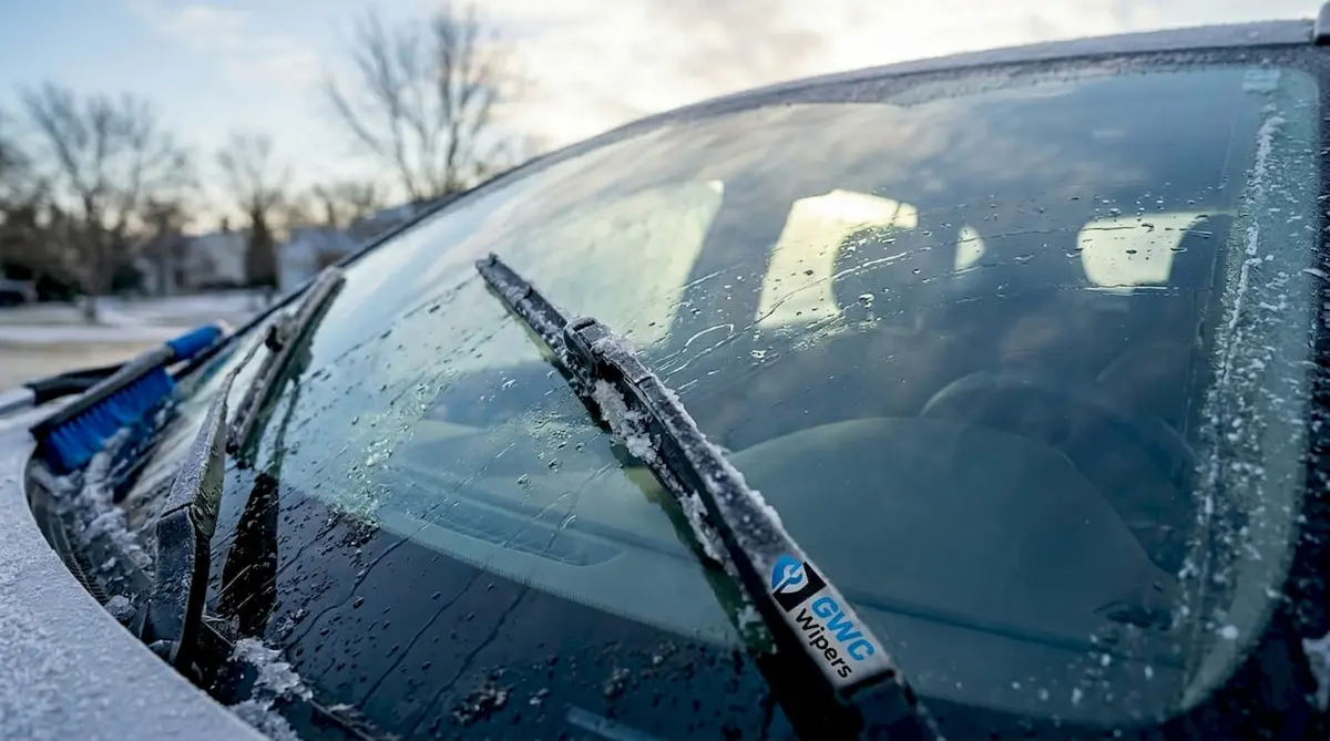 Winter wiper blades clearing frosty windshield