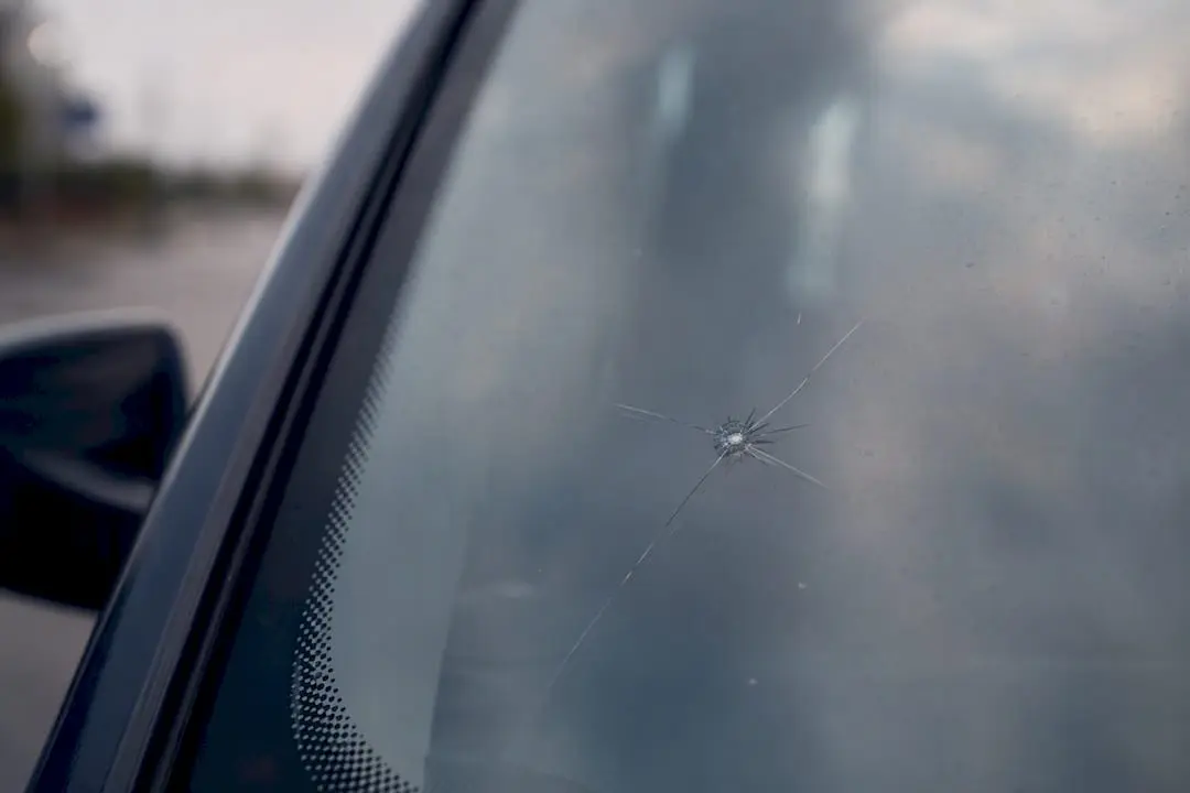 Close-up of stone chip on windscreen glass