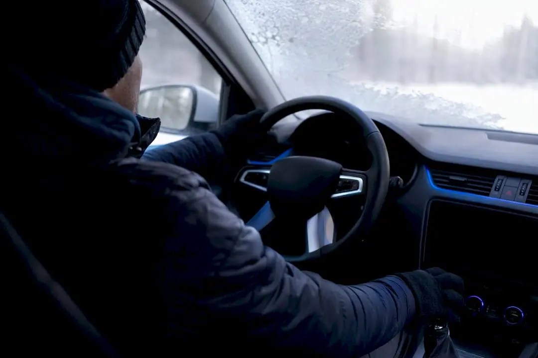Driver wearing layered clothing controlling steering wheel