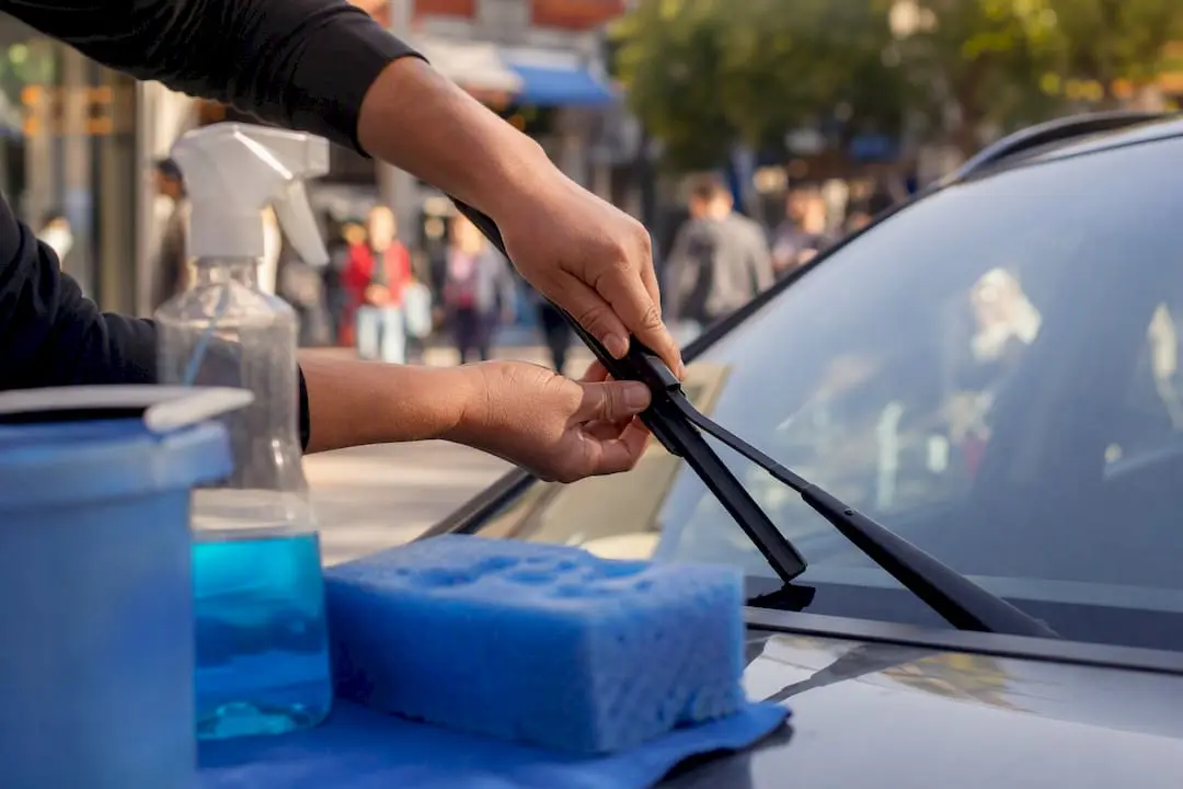 Hands replacing wiper blade on windscreen