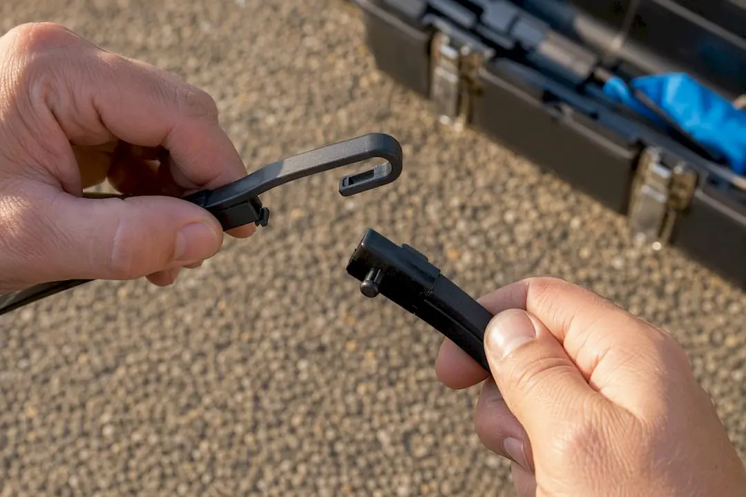 Hands inspecting two types of wiper arm connectors