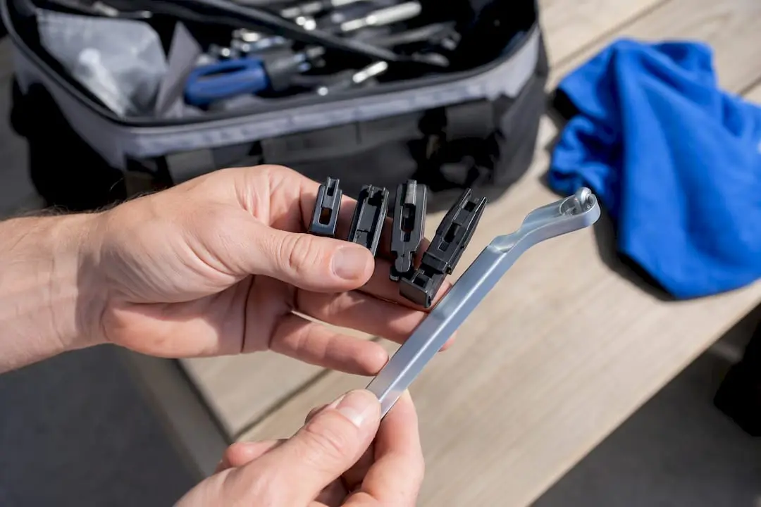 Hands holding rear wiper arm connector types