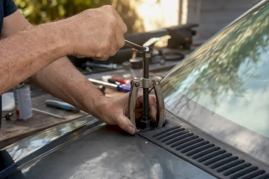 Hands using wiper arm puller tool