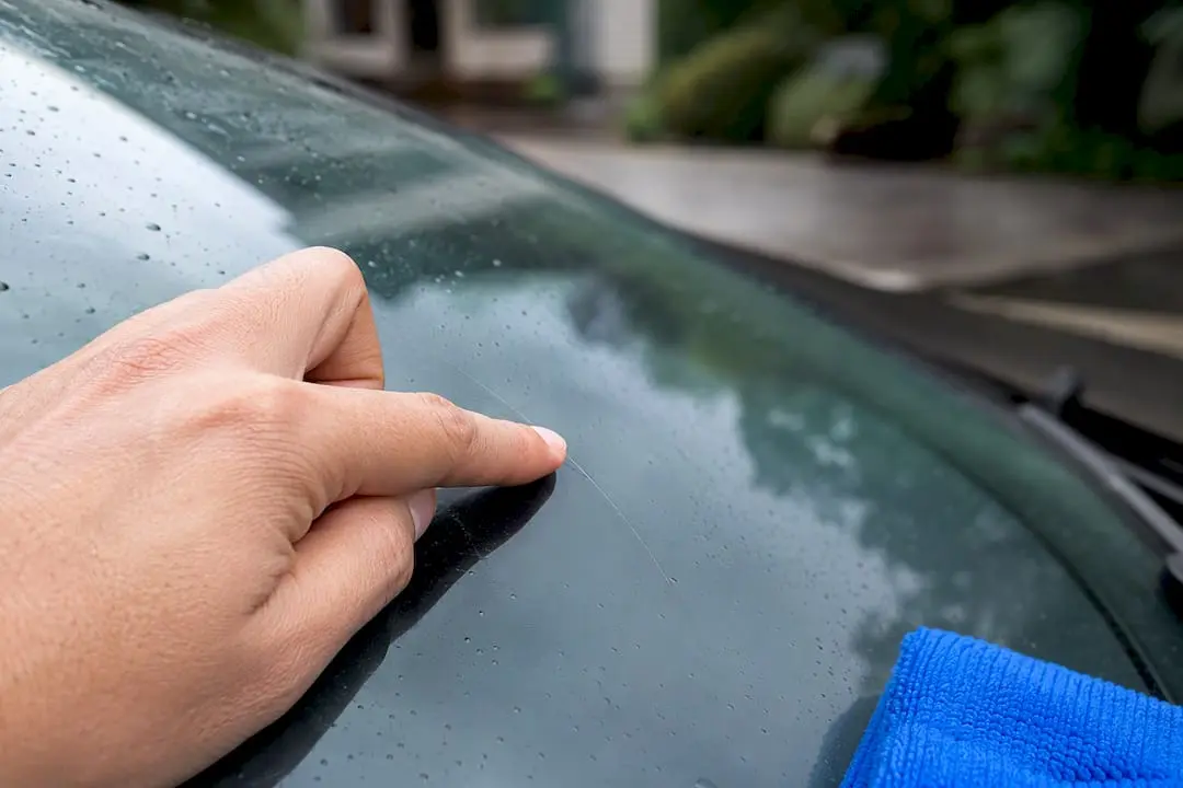 Fingernail testing scratch on windscreen glass