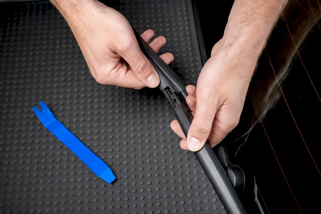 Hands releasing a rear wiper blade clip