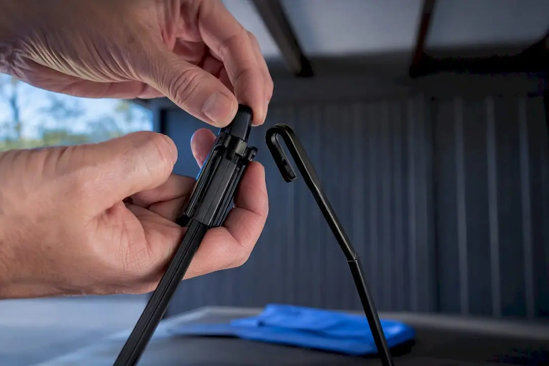 Hands releasing pinch tabs from wiper arm