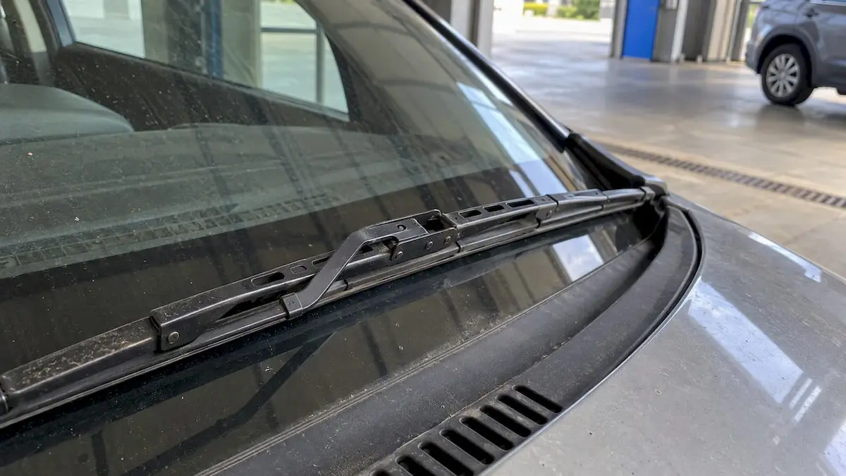 Metal arms and clips above a conventional blade’s rubber